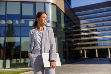 Obraz premium A selfassured businesswoman confidently stands outside a sleek and modern office building during the day