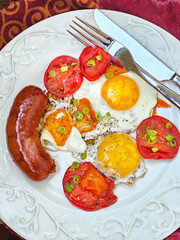 Fried eggs with sausage and tomatoes