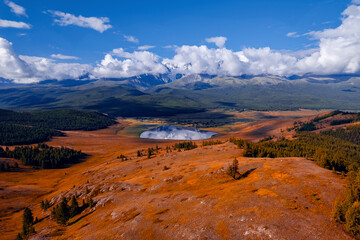 Autumn landscape Altai yellow forest crystal clear lake Dzhangyskol and snowy mountain peaks, aerial view