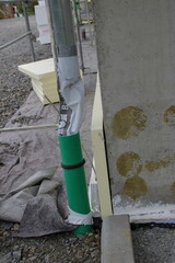 Wasser von einem Fallrohr wird mit einem Schlauch umgeleitet