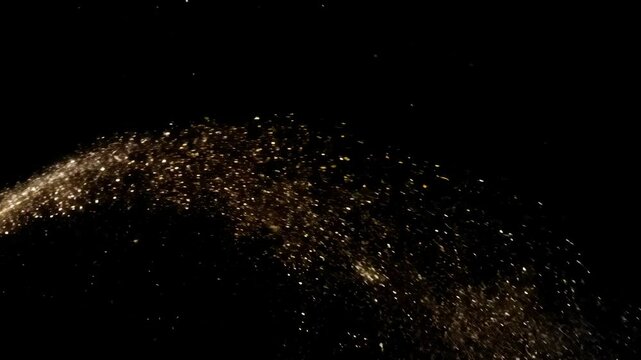 Wide shot of sparkling dust arcing