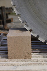 Sägeblatt einer Steinsäge steht an einem Mauerstein an