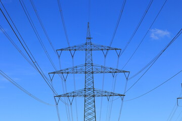 Hochspannungsmast vor einem blauen Himmel