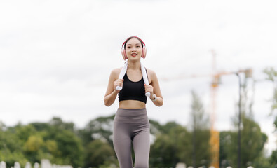 Post-Workout Glow:  A young woman, radiating health and vitality, strolls through a park after a...