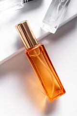 Orange glass perfume bottle with golden cap. Vertical