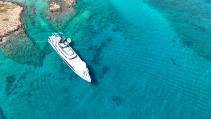 Aerial drone photo of yachts and sail boats anchored in tropical exotic island complex with crystal clear turquoise sea forming a blue lagoon