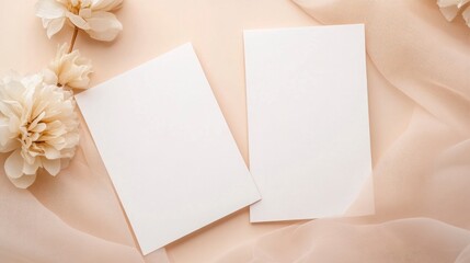 Two blank white cards on top of beige tulle fabric with beige color roses