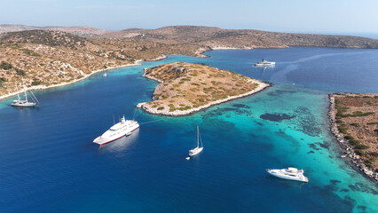 Aerial drone photo of yachts and sail boats anchored in tropical exotic island complex with crystal clear turquoise sea forming a blue lagoon