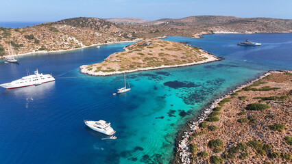 Aerial drone photo of yachts and sail boats anchored in tropical exotic island complex with crystal clear turquoise sea forming a blue lagoon