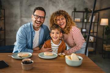 portrait of mother, father and son while have breakfast together
