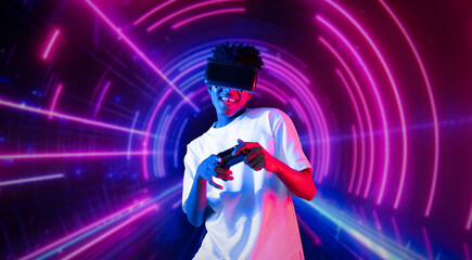 Teenager holding joystick and wearing VR goggles while enjoy playing games at neon abstract background. African man enjoy controlling controller and using augmented reality technology. Ingenuity.