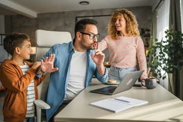 the father try to work from home while his family distracts him
