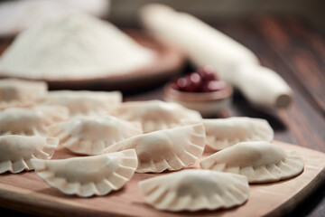 raw dumpling with cherries on the wooden board