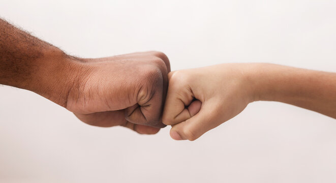 Family unity. Closeup of fist bump of african american man and little boy, his son over white background, cropped - Powered by Adobe