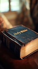 Close-up of an antique Holy Bible resting on a wooden surface.