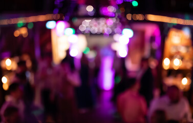 Blurred party background with colourful lights and shadowy figures