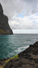 Seaside view with ocean waves crashing against rocky cliffs in Madeira, Portugal 