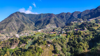 Lush green mountain landscape in Madeira with scattered village houses