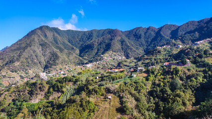 Lush green mountain landscape in Madeira with scattered village houses