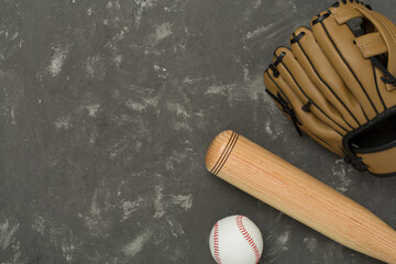 Baseball glove and bat with ball on concrete background, top view