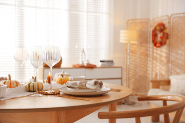 Stylish table setting with beautiful dishware and autumn decor in dining room
