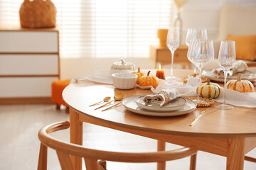 Stylish table setting with beautiful dishware and autumn decor in dining room