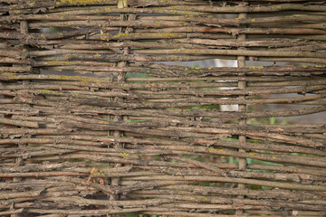 Fragment of a wicker fence made of willow branches. Natural background. © ROMAN DZIUBALO