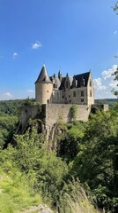 Majestic Castle on a Hilltop: A picturesque castle stands tall on a verdant hilltop, its imposing towers reaching for the azure sky.
