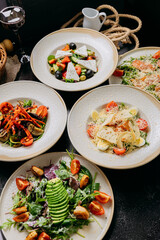 Assorted gourmet salads with ingredients like avocado, smoked salmon, feta and grilled vegetables