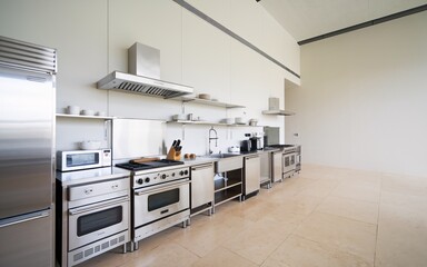 Modern kitchen with stainless steel appliances and open shelves.
