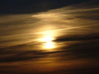 Dark sky with yellow and orange clouds and sunlight during sunrise - natural background. Topics: sun energy, weather, meteorology, atmosphere, air space