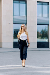 Naklejka premium European young business woman uses lunch break to take a walk and drink coffee
