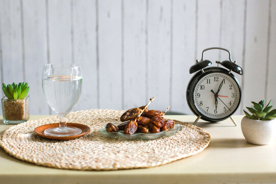 Dates on plate and glass of water beside alarm clock