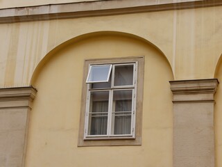 Yellow Stucco Wall with Classic European Architecture Featuring an Open Window with Minimalist Design