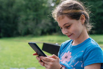 Young girl with a blue top playing with a cellphone