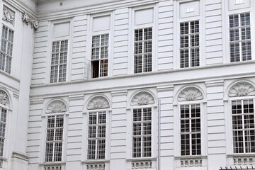 Historic White Facade with Ornate Details and Open Window, Perfect for Architecture Themes or Copy Space in Urban Travel Ads