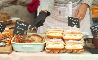 Midsection body of a baker at a stand at the farmers market selecting a sweet pastry for a customer