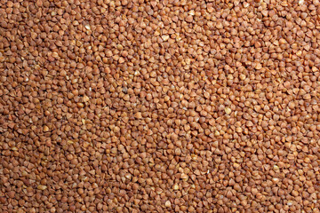 Dry Uncooked Brown Buckwheat Groats Background - Top View, Flat Lay. Raw Large Buckwheat Grains. Russian, Ukrainian and Belarusian Culture