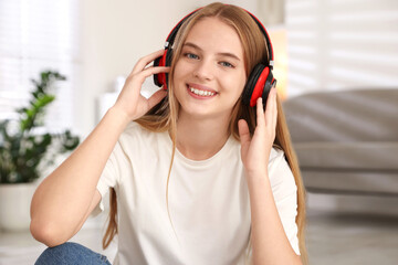 Naklejka premium Portrait of teenage girl in headphones at home