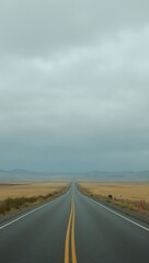 Fototapeta premium Endless road across open plain under cloudy sky