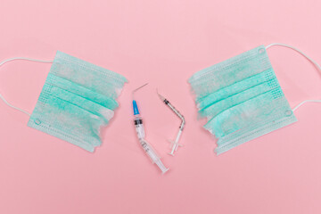 Anti Vaccine Movement and Anti Mask Concept - Broken Medical Syringe and Green Torn Medical Face...