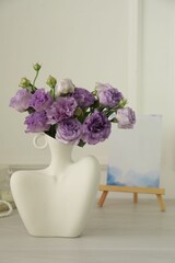 Stylish vase with beautiful flowers and decor on white wooden table at home