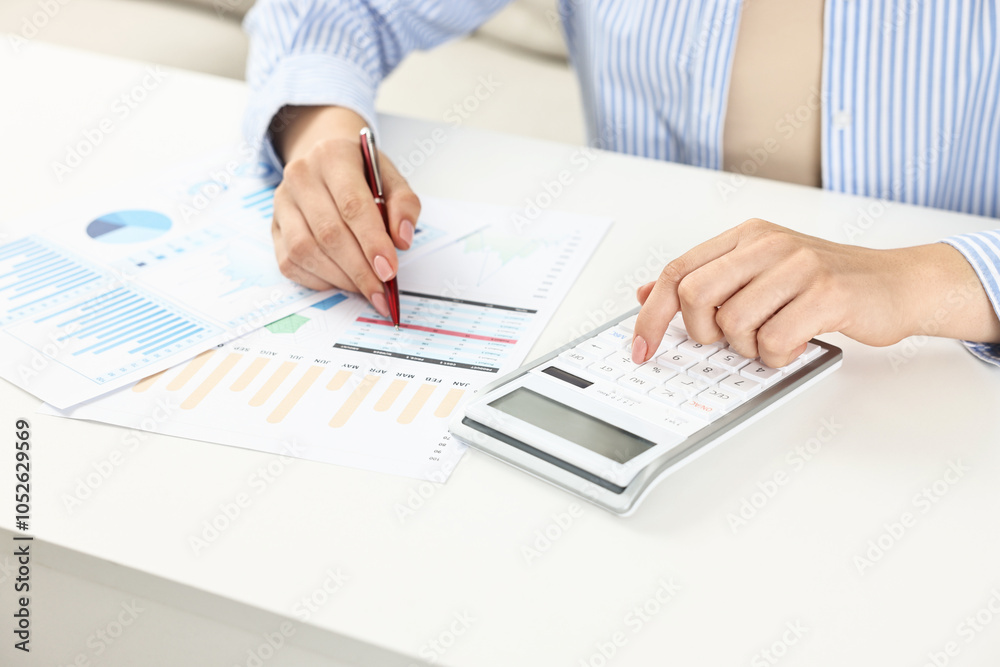 Wall mural budget planning. woman with papers using calculator at white table, closeup