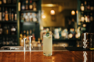 Close up shot of cocktails on a wooden rustic bar with ice and fruit garnish
