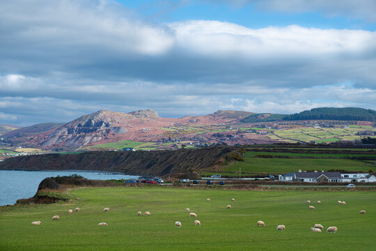 Nefyn on the Llŷn Peninsula in North Wales, showing colorful farmland, mountains, and sea under a dramatic sky