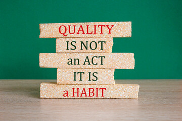 Quality is a habit symbol. Concept red words Quality is not an act it is a habit on brick blocks....