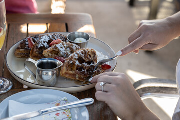 Lightly dusted belgian waffles with powdered sugar and maple syrup is a sweet breakfast treat to eat