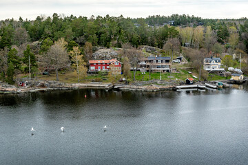Fototapeta premium Small idyllic port in the Swedish archipelago outside of Stockholm with beautiful reflection lighted with sunspot at autumn evening. 