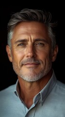 Obraz premium Close-up Portrait of a Man with Graying Hair and a Light Blue Shirt