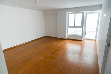 Fototapeta premium habitacion vacía de departamento con ventana , acabados modenos piso de melamina, y paredes color blanco